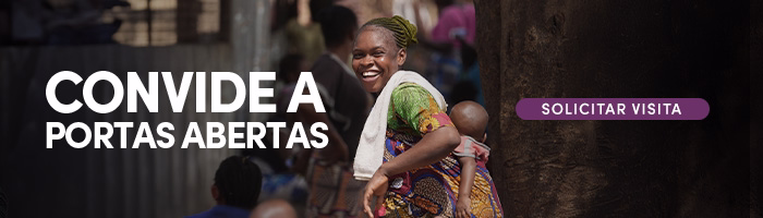 Mulher sorridente carrega uma criança em uma faixa nas costas. E há o texto Convide a Portas Abertas