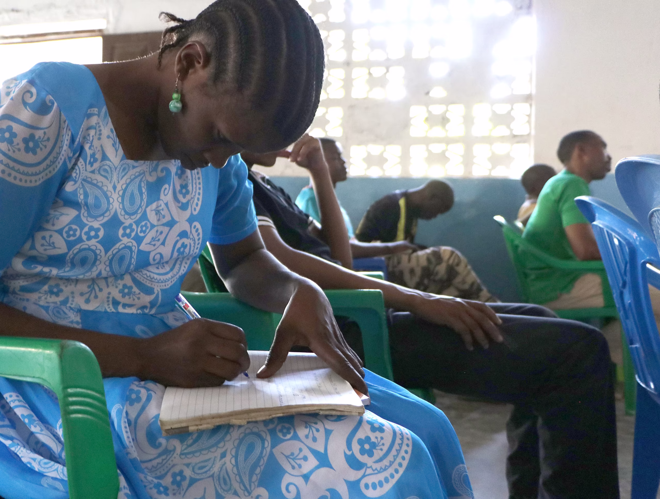 Mulher faz anotações durante culto no leste africano