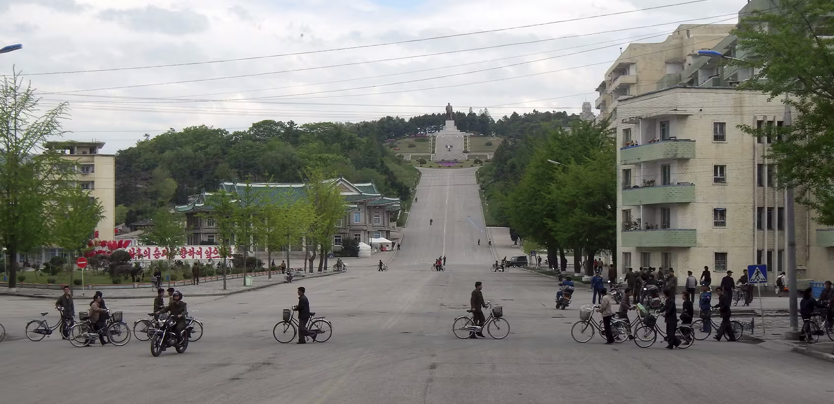 Norte-coreanos circulam pela rua em sua bicicletas