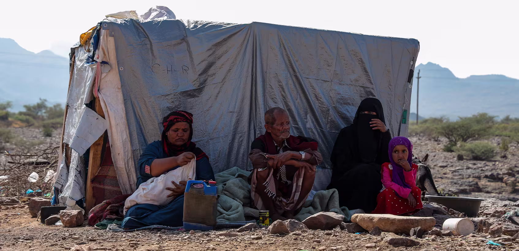 Família iemenita em meio a um local desolado