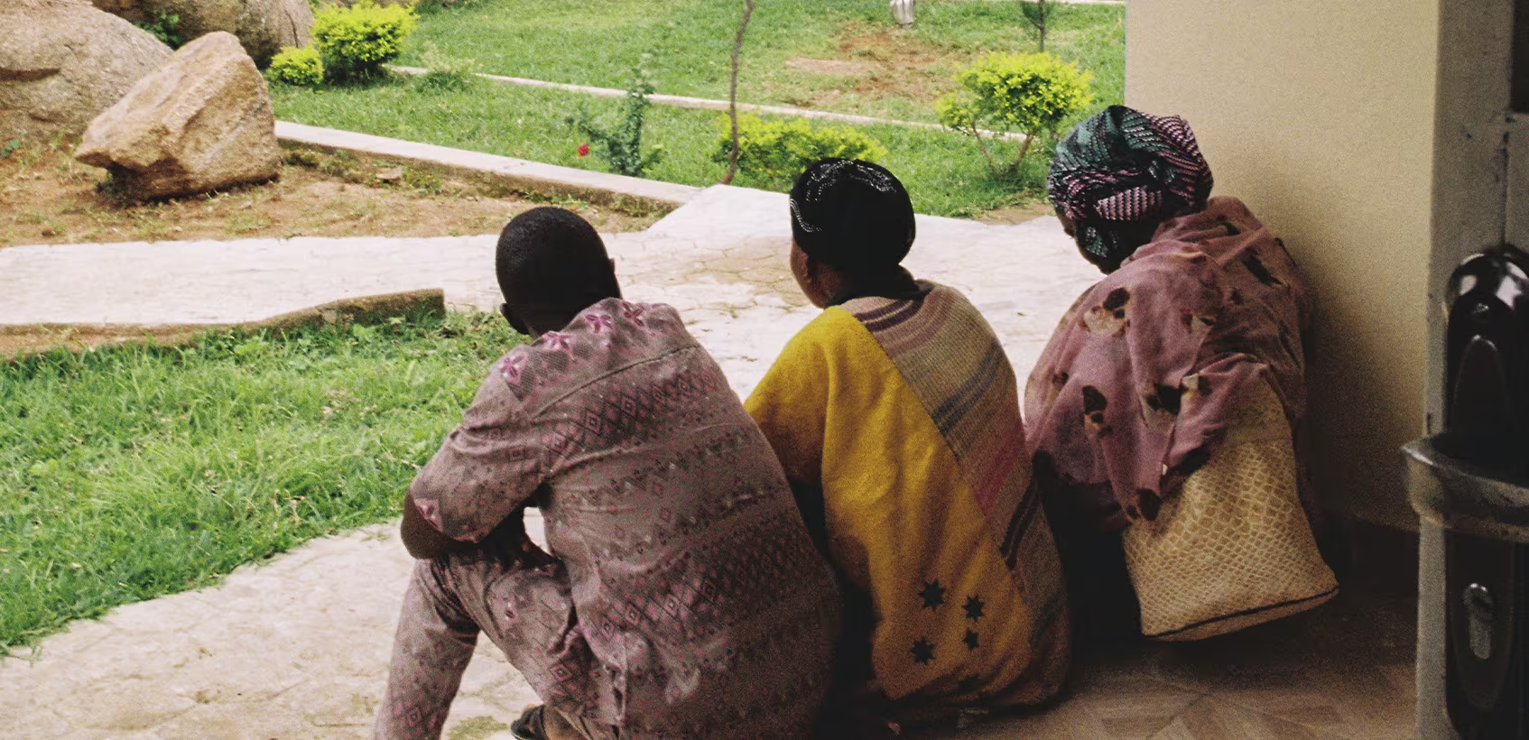 Família nigeriana sentada na entrada de casa