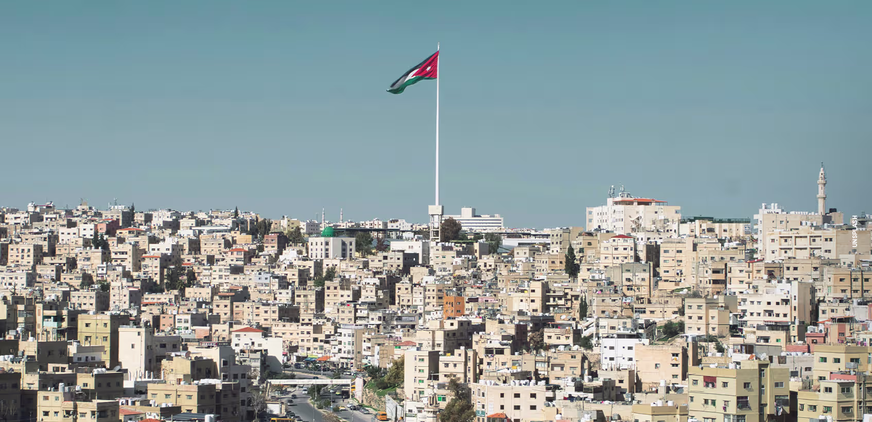 Cidade na Jordânia. É possível ver a bandeira nacional tremulando em destaque.