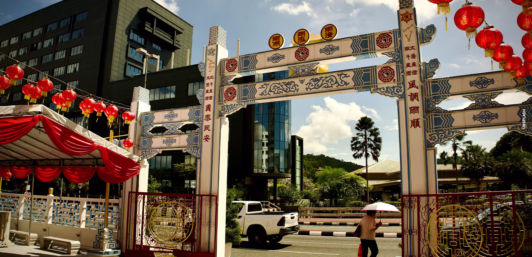 Rua de uma cidade em Brunei. Há um pórtico decorado no estilo da cultura local.